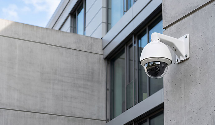 Outdoor dome video security camera mounted on a modern commercial building wall