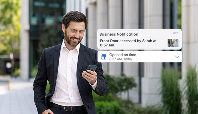 Businessman viewing real-time security and door access notifications on a smartphone