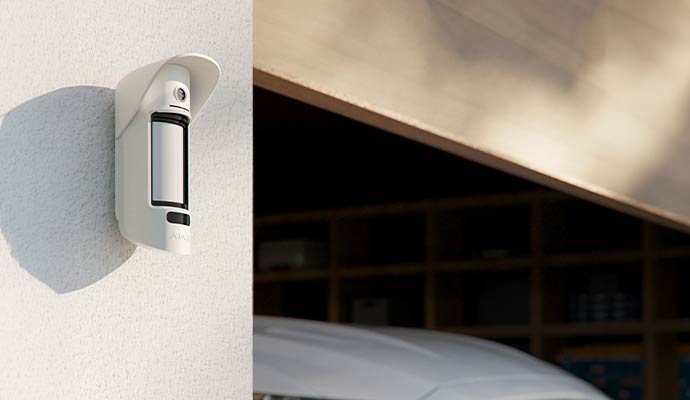 Commercial indoor motion sensor detector mounted on an office hallway wall