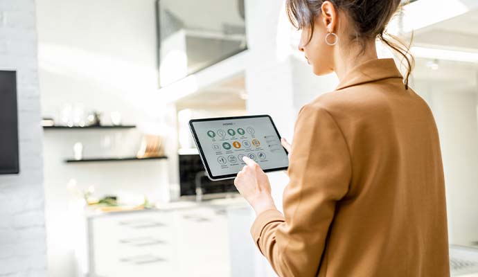 Homeowner managing interactive home security settings on a tablet