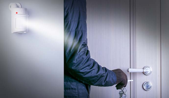 Motion detector sensor illuminating and detecting an intruder at a door